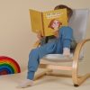 Kind sitzt im Kindersessel mit Windelweg Hose und ließt das Buch "Mia will's wissen" von Aylin Knapp