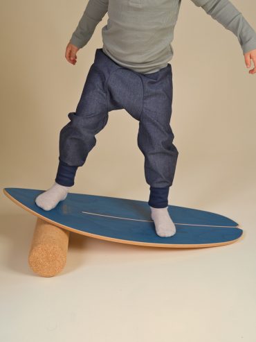 Kind in Windelweg Hose - Jeans Spirit - balanciert auf einem Board