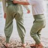 Zwei Kinder spielen am Flussrand und beide tragen die Windelweg Hose Auengrün, die sie beim Trockenwerden begleitet