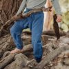 Kind spielt mit Ast und trägt eine Windelweg Hose in Flussblau als Sicherheit beim Trockenwerden